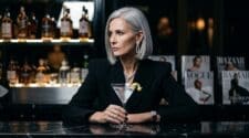 Severe fashion editor with martini at a marble luxury hotel bar