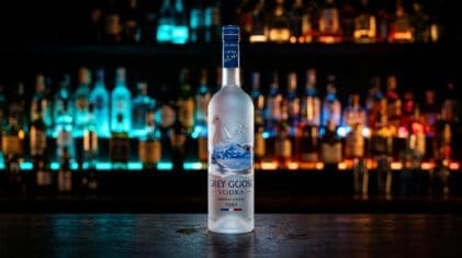 Grey Goose vodka bottle on a dark bar.