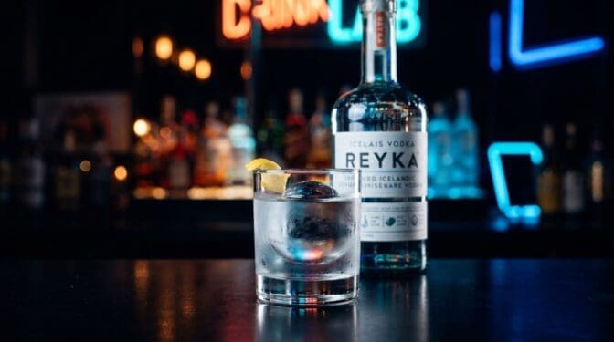 Reyka Vodka bottle on a dark bar.