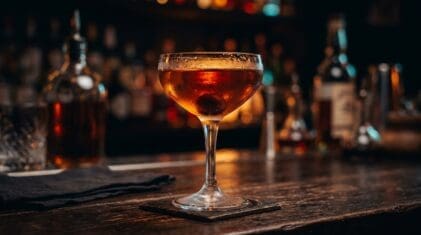 Bourbon Manhattan cocktail with a brandied cherry in a crystal coupe